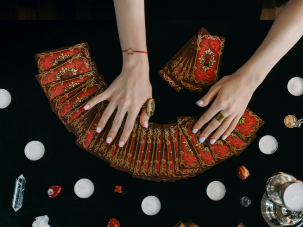 Image d'une main féminine tirant une carte du tarot de l'amour sur un fond de velours pourpre